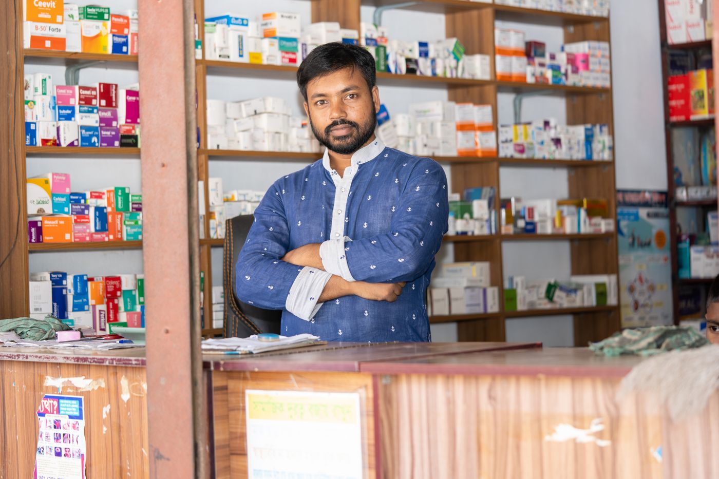 A pharmacist at the counter of a neighbourhood medical shop